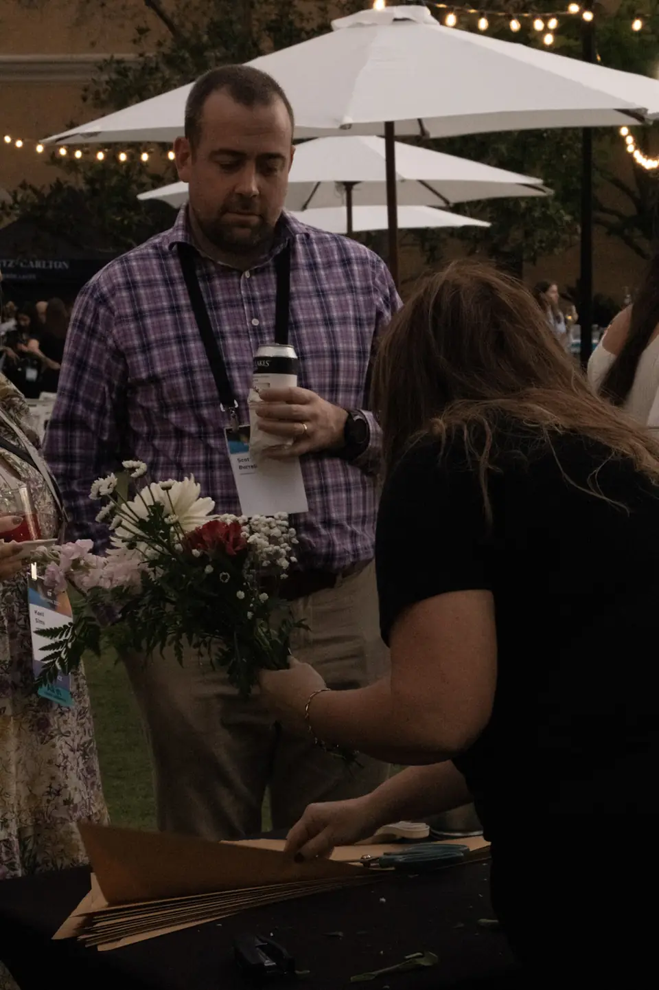 Flowerista wrapping a bouquet at a corporate event, Orlando